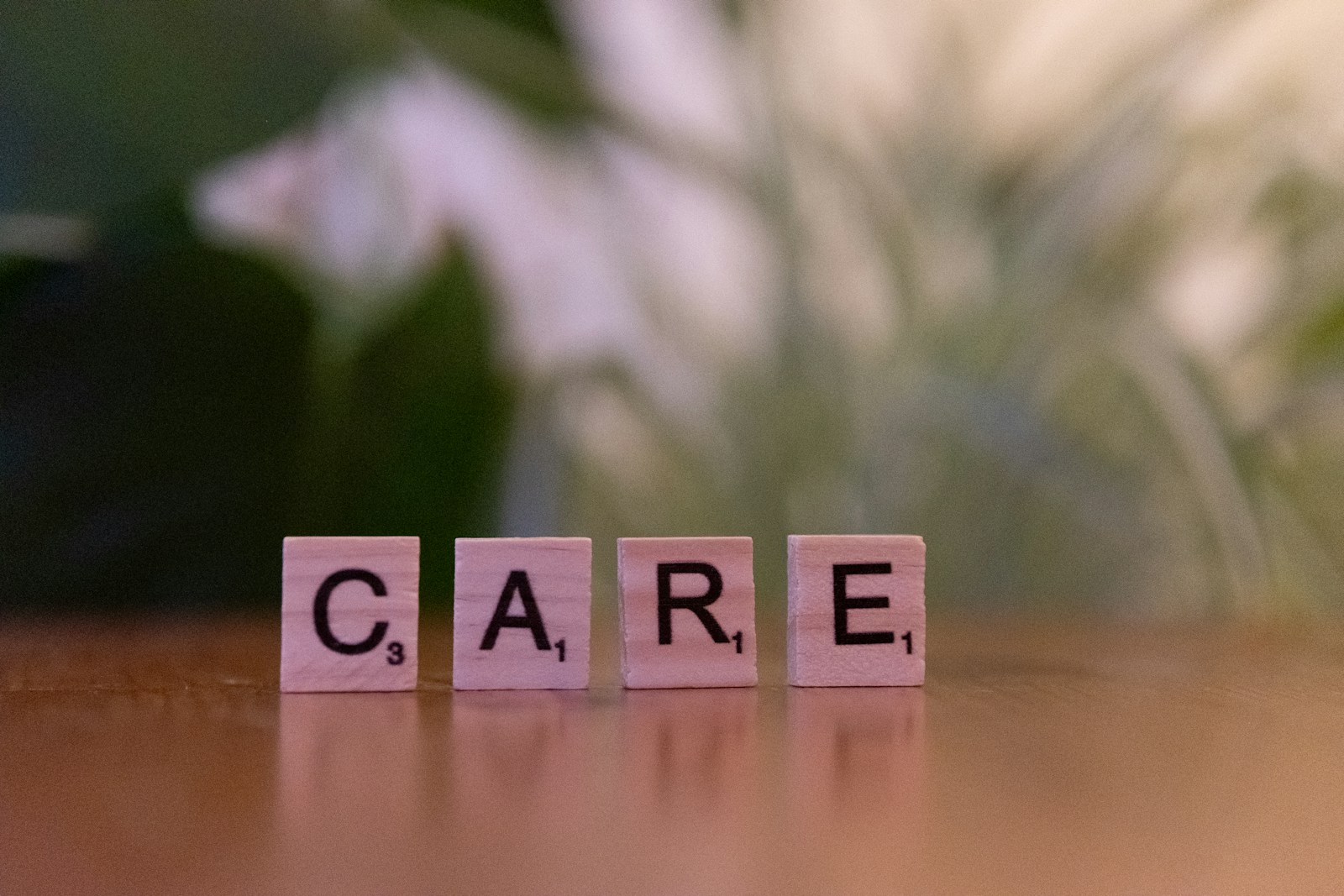 A wooden block spelling care on a table; 2027 ACA premium increase