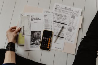 person holding paper near pen and calculator; de minimis safe harbor