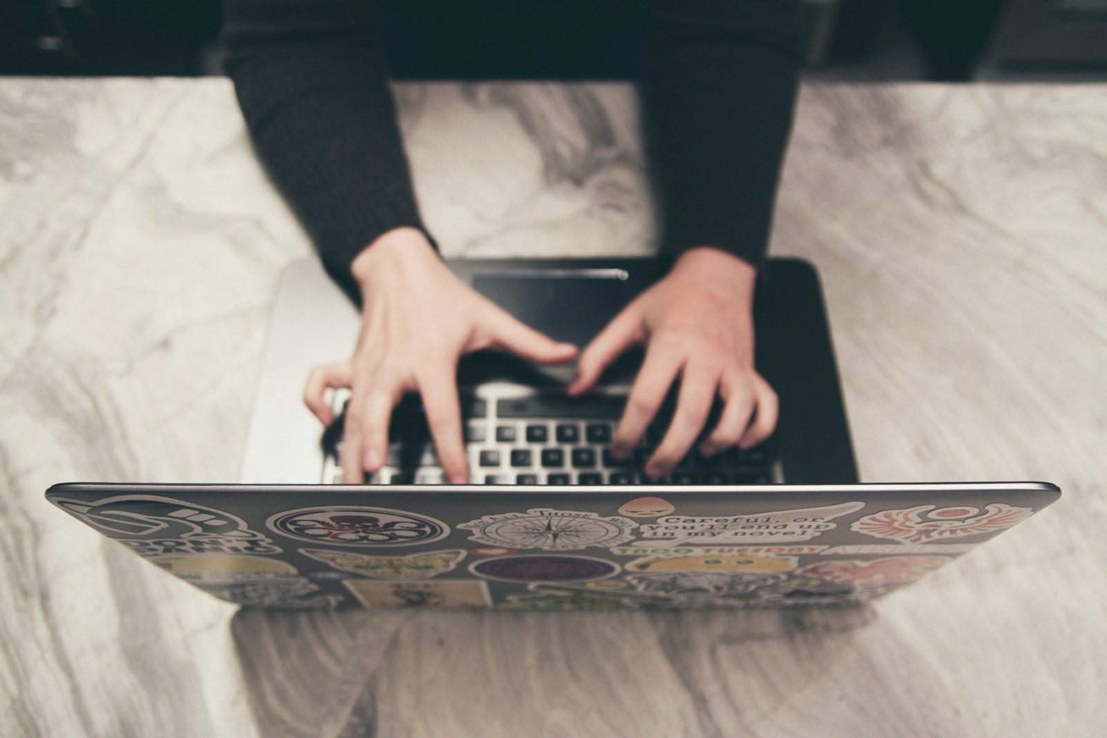 person typing on MacBook; Gigbuz freelance marketplace