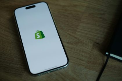 A cell phone sitting on top of a wooden table; Shopify Q2 2026 results