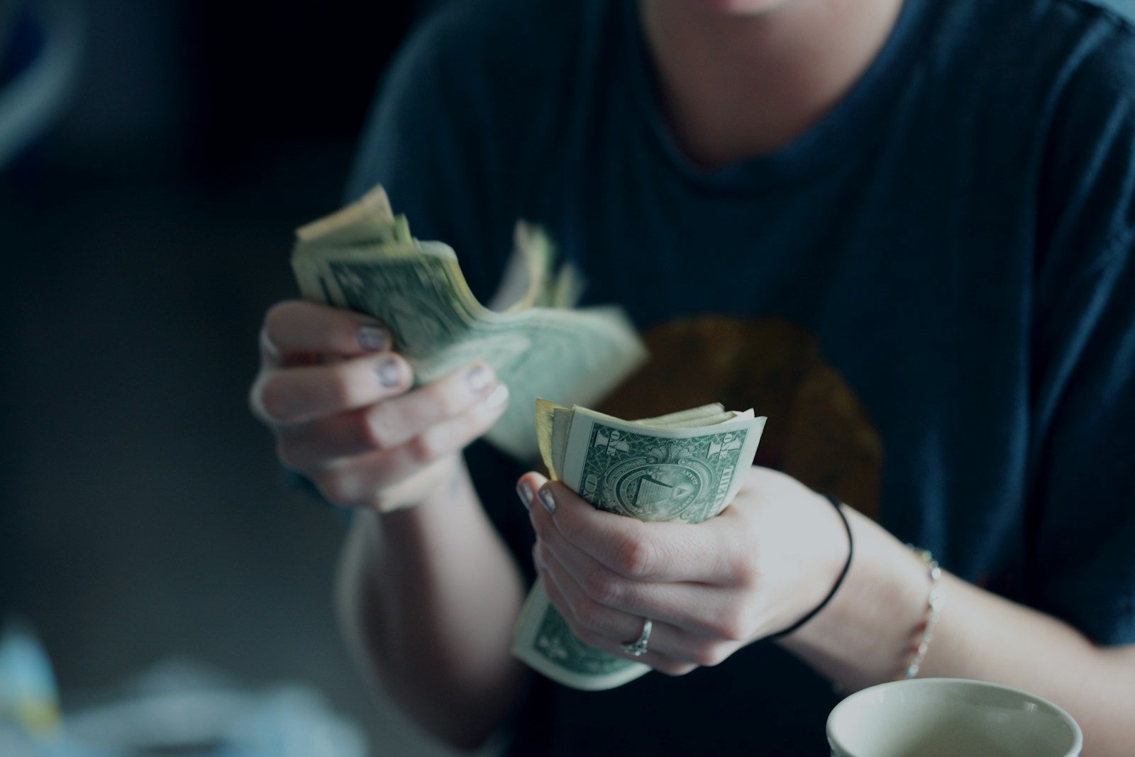 focus photography of person counting dollar banknotes; invoice factoring