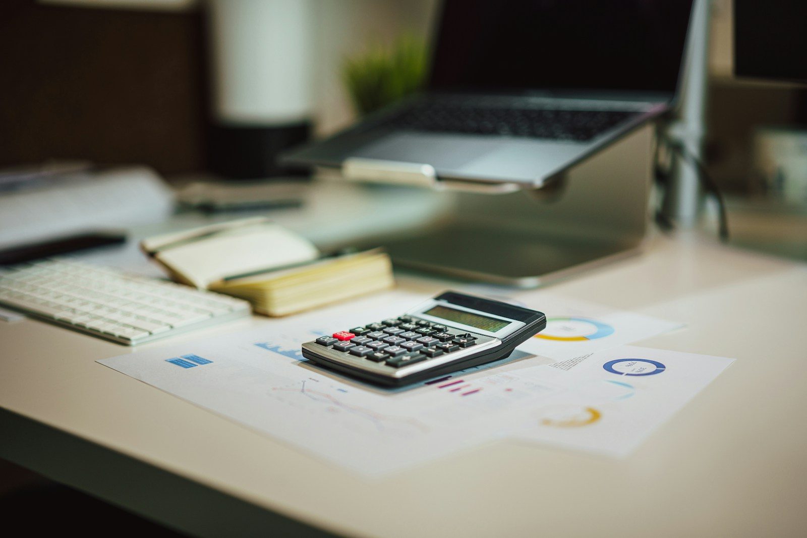 a calculator sitting on top of a table next to a laptop; quarterly estimated taxes