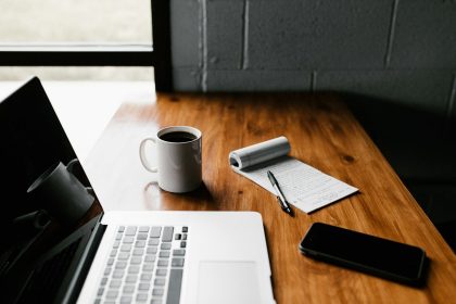MacBook Pro, white ceramic mug,and black smartphone on table; Roth SEP IRA self-employed
