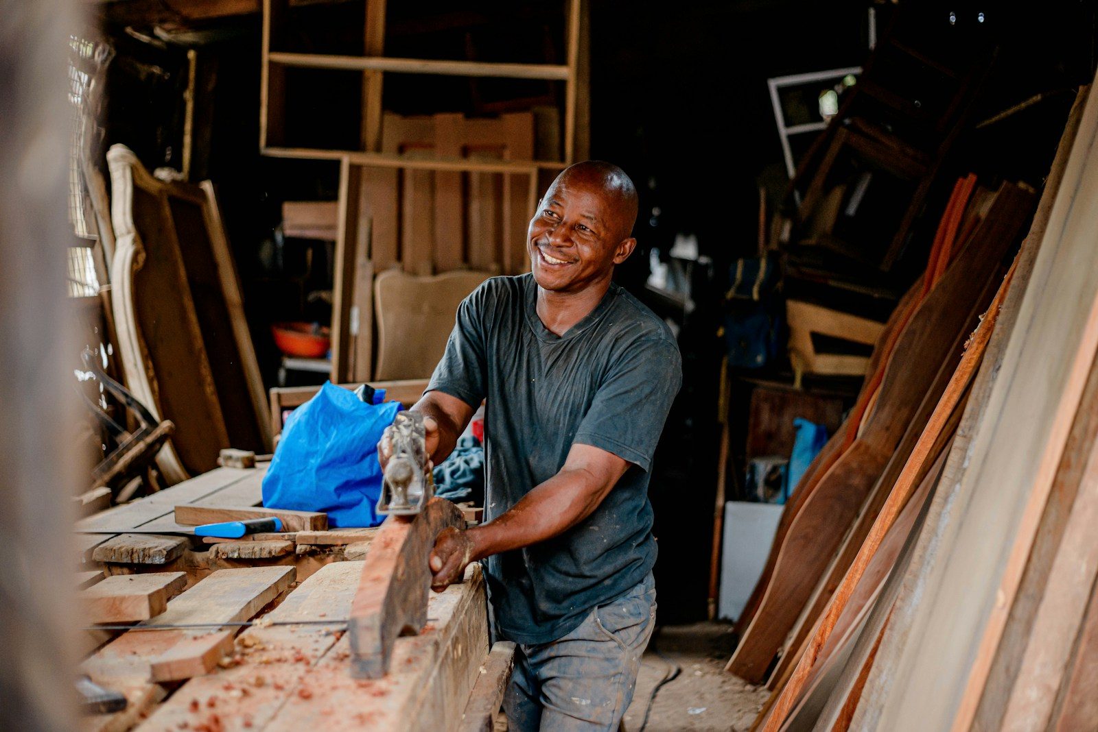 a man smiles as he works on a piece of wood; SBA 8(a) social disadvantage rule