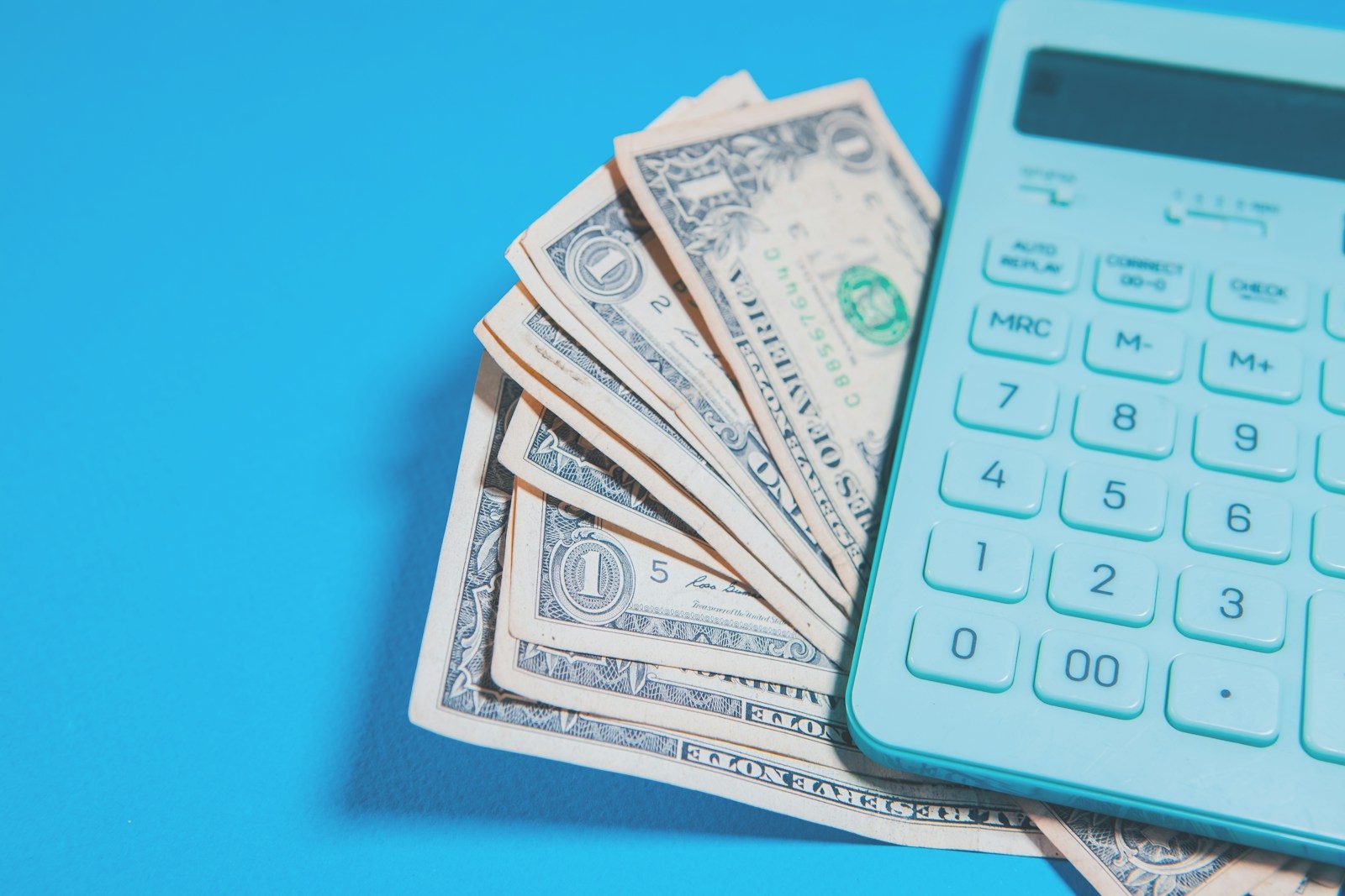 Us dollar bills and a calculator on blue background; IRS Business Tax Account