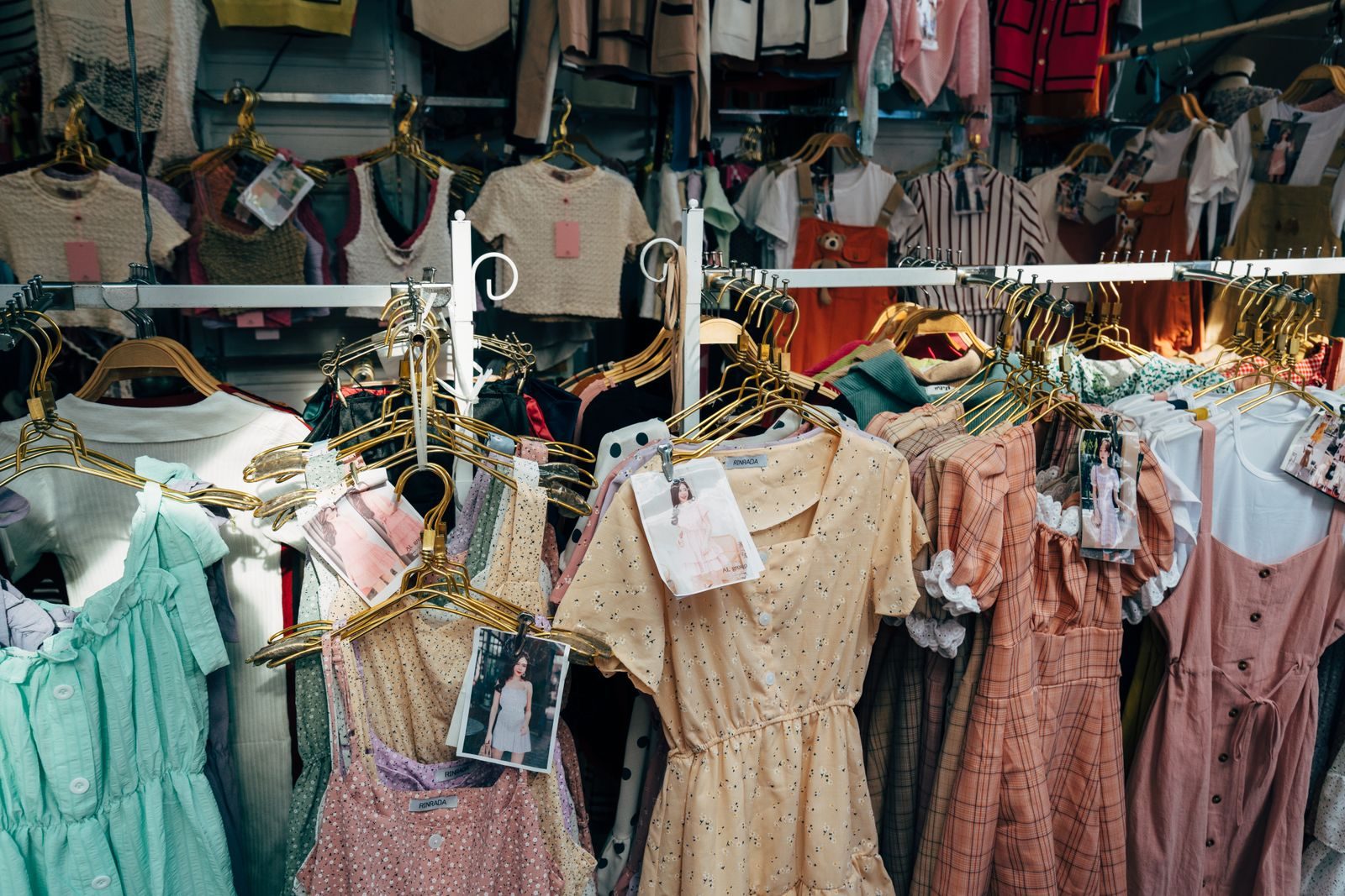 A colorful assortment of dresses hanging on a clothing rack in a trendy fashion boutique; TikTok Shop Seller Center