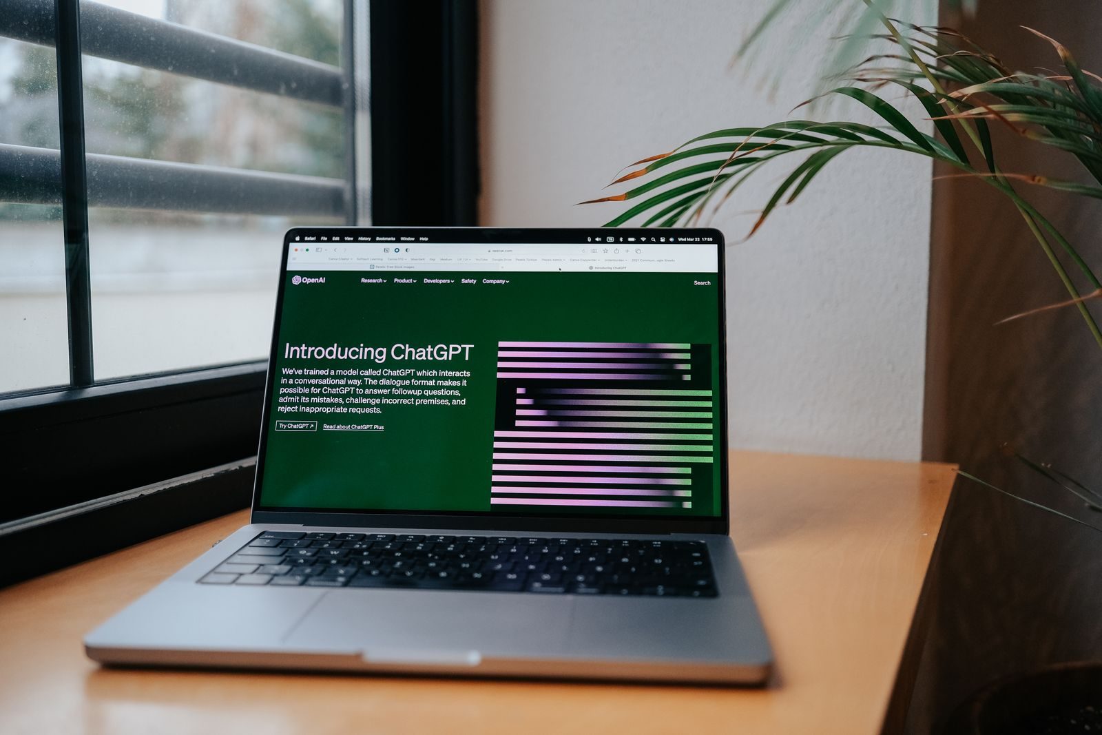 A laptop displaying ChatGPT on a desk by a window, featuring a modern home office setup; ChatGPT Ads Shopify