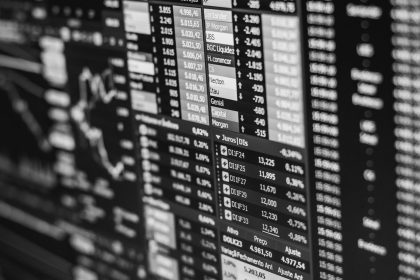 Monochrome image of stock market data on a screen, depicting financial information and trends; AI benefits brokerage