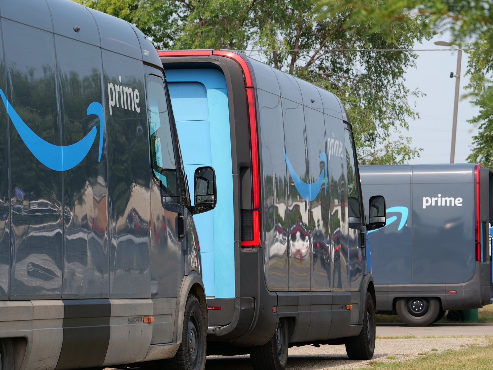Amazon Prime delivery vans lined up for logistics operations in an urban setting; Amazon product bundle policy