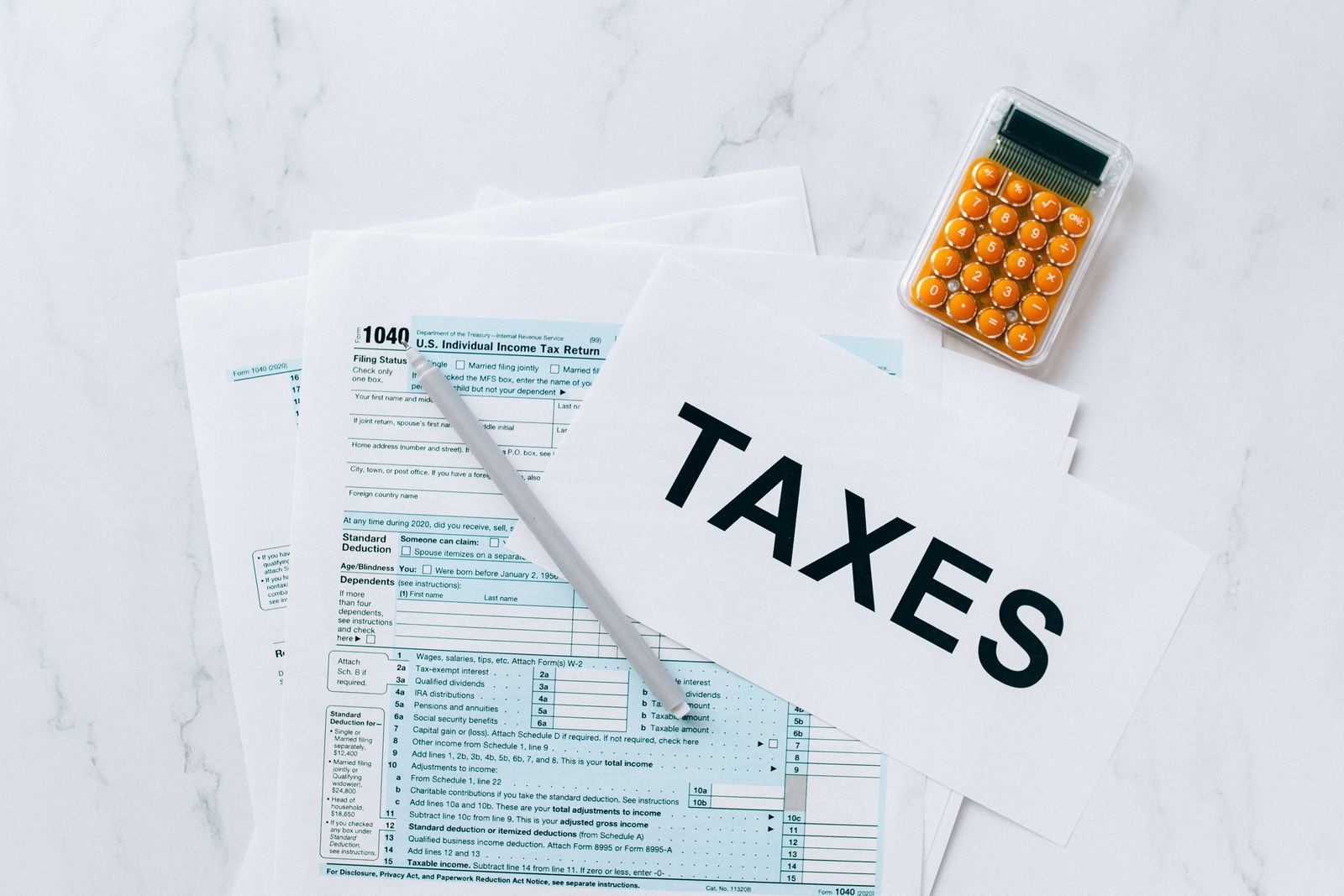 Top view of tax forms, a calculator, and pen for tax preparation; IRS Direct Pay