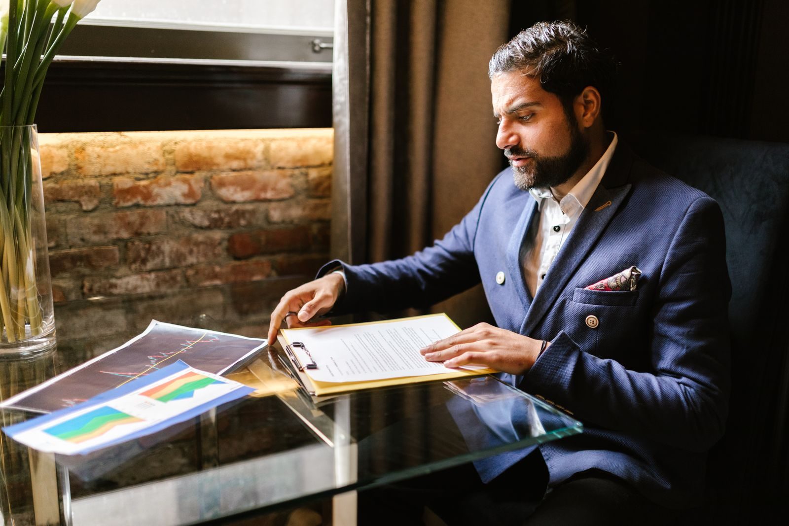 A businessman in a suit reviewing financial documents at a desk in an office setting; ZenBusiness state of entrepreneurship report