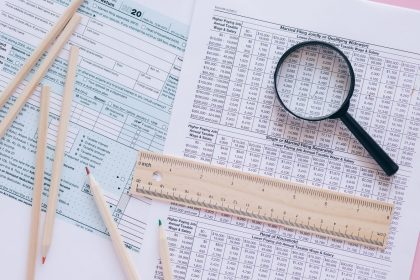 A high angle view showing IRS tax forms with pencils, ruler, and magnifying glass for financial planning; 2027 tax brackets