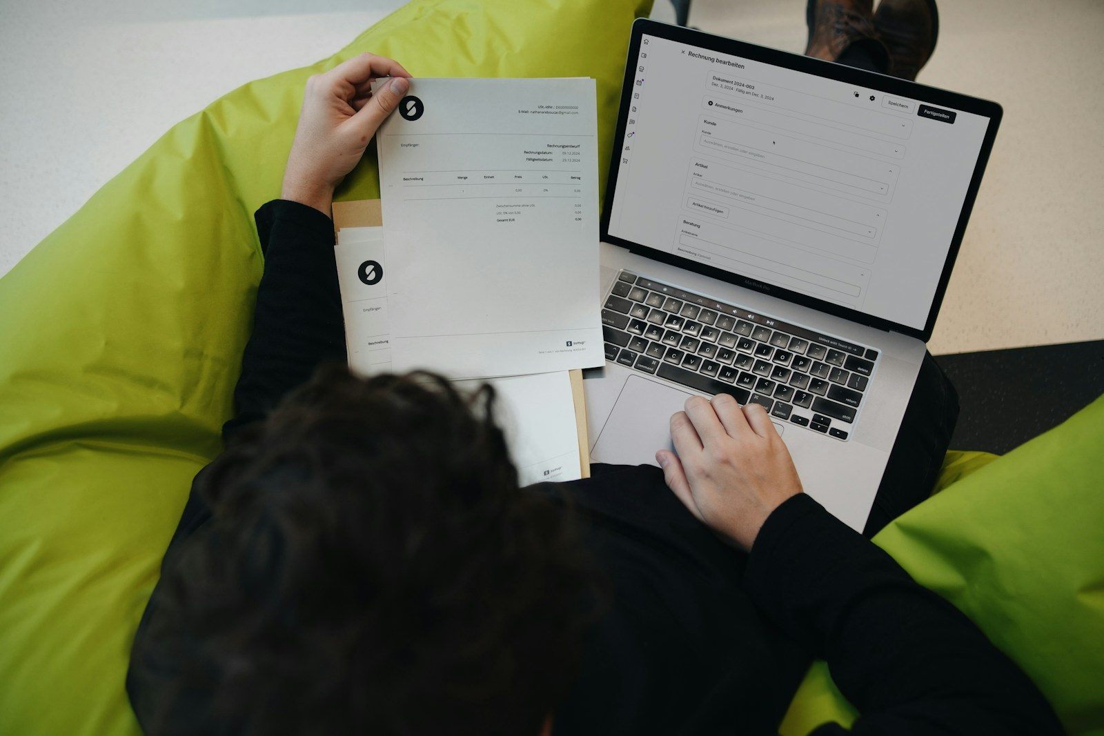 A person sitting on a bean bag chair working on a laptop; GloPay freelancer invoicing