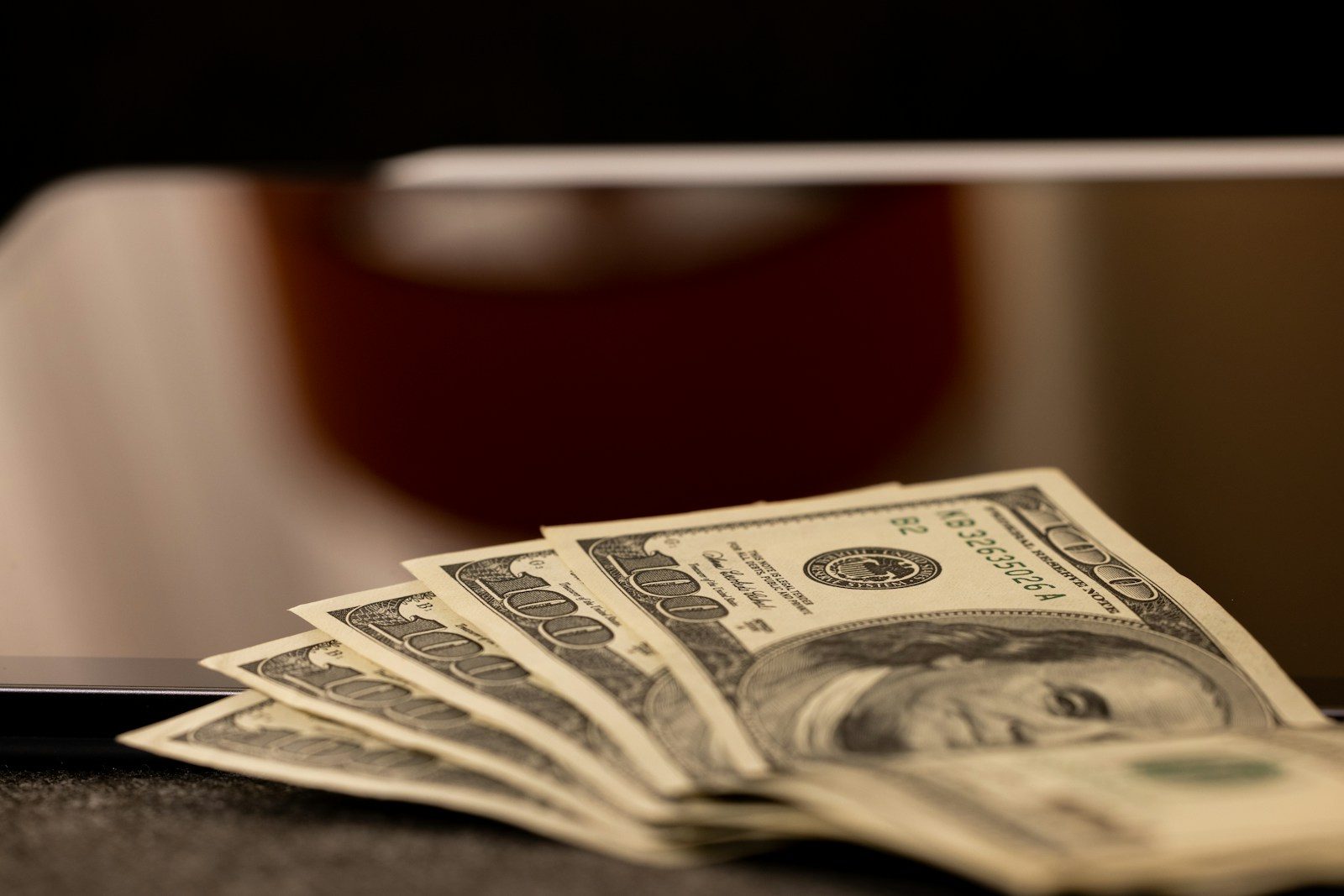 a stack of money sitting on top of a laptop computer; Upwork withdrawal fee