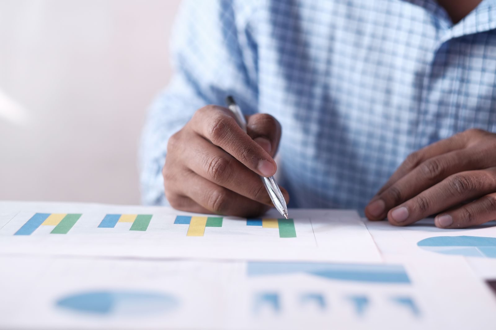 Close-up of hands analyzing colorful graphs, indicating business planning; ADP September jobs report