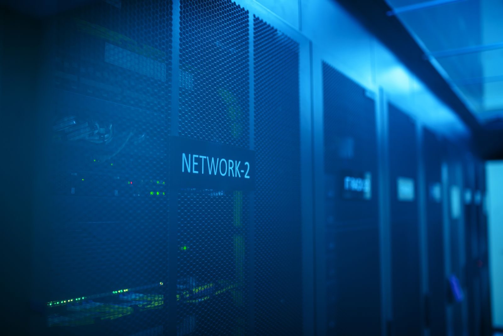 A modern server room featuring network equipment with blue illumination. Ideal for technology themes; self-hosted AI security