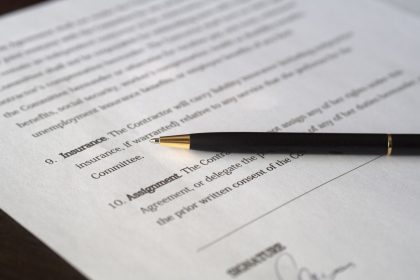 Close-up image of a business contract and pen, signed and ready for agreement; business insurance regret