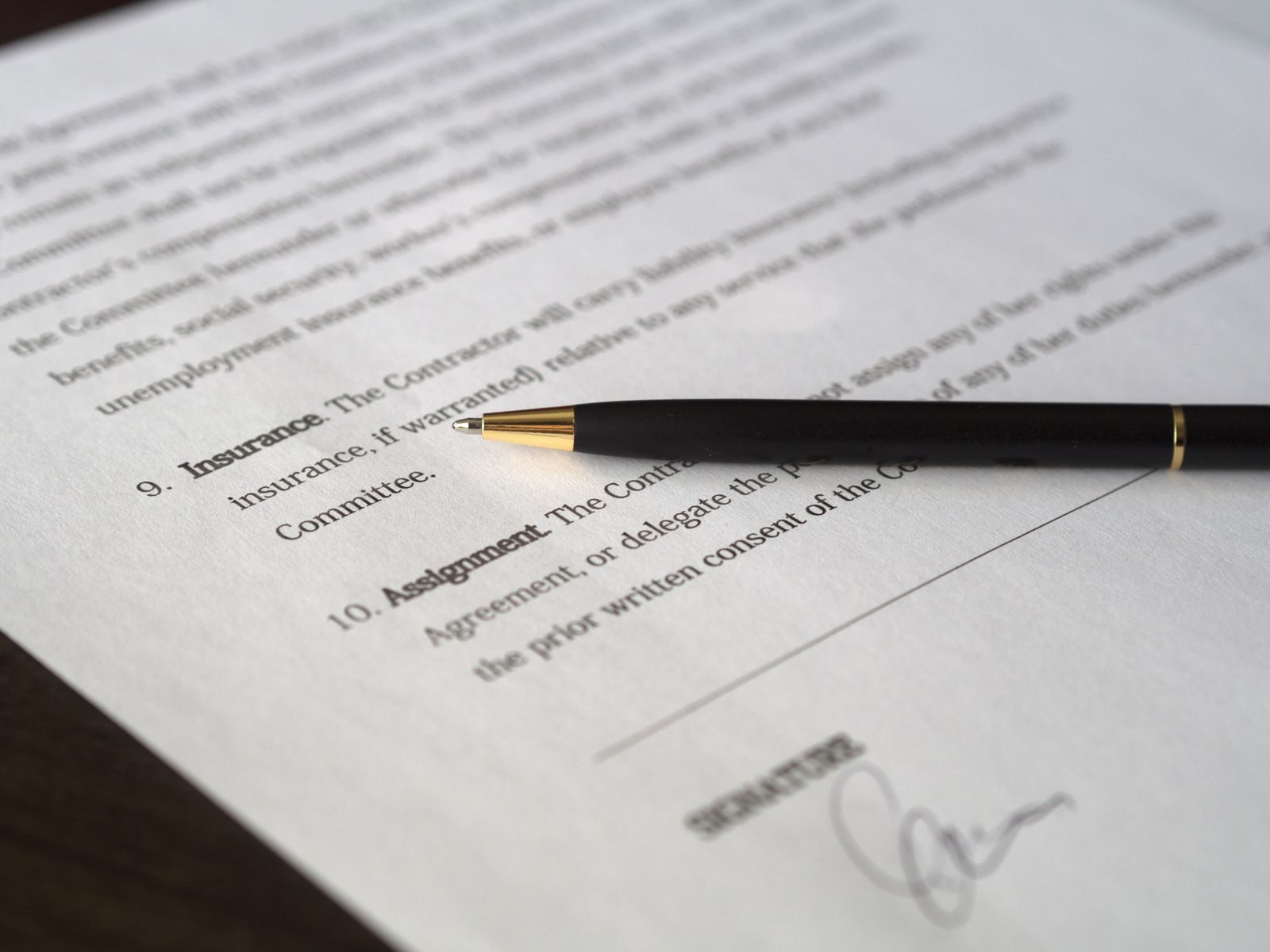 Close-up image of a business contract and pen, signed and ready for agreement; business insurance regret