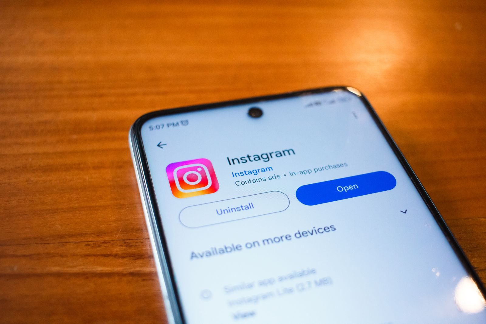 A smartphone displaying the Instagram app open option on a wooden table; Instagram Features