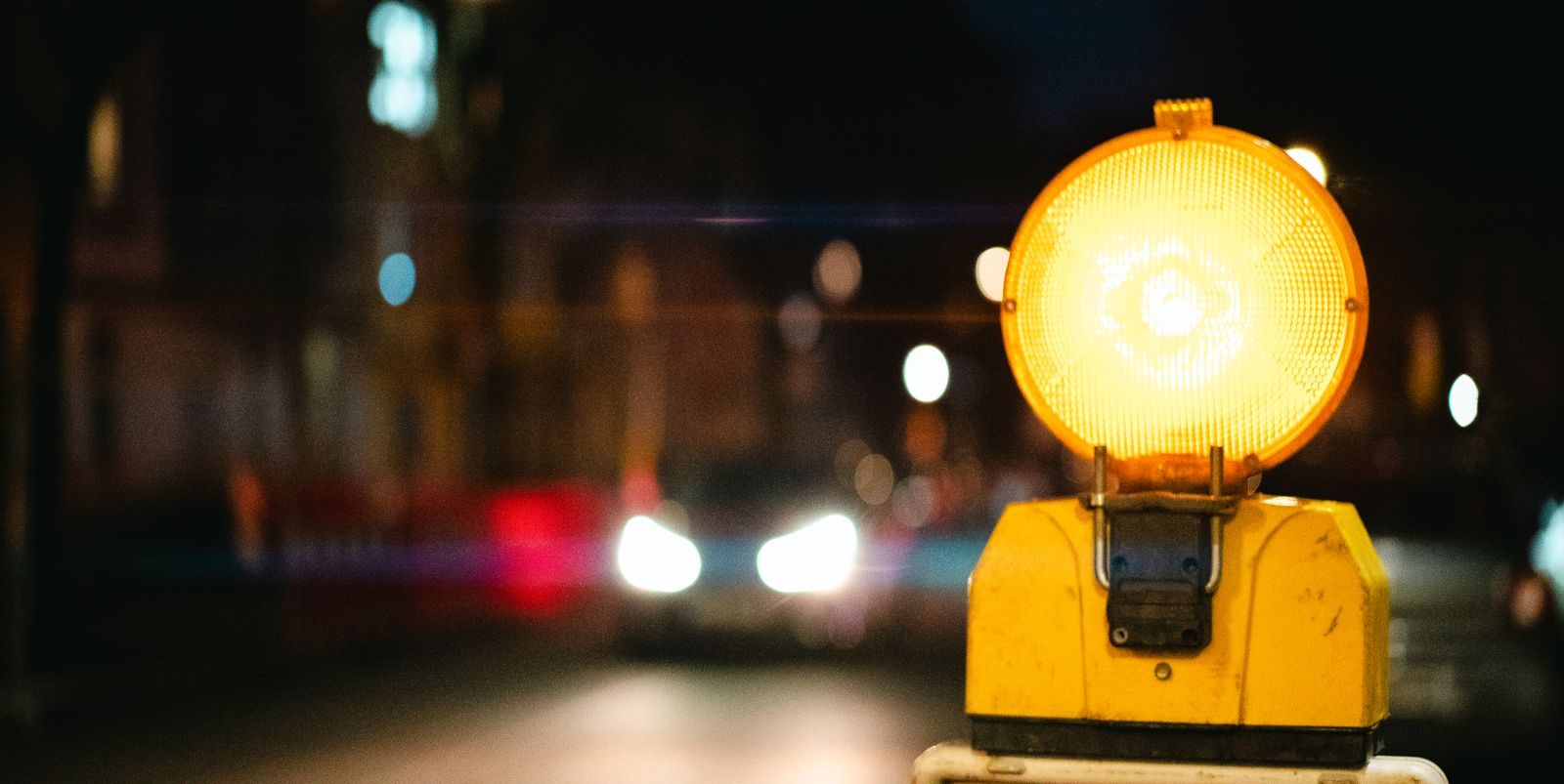 A night scene showing a bright yellow traffic warning light in an urban setting; free Gemini Flash-Lite