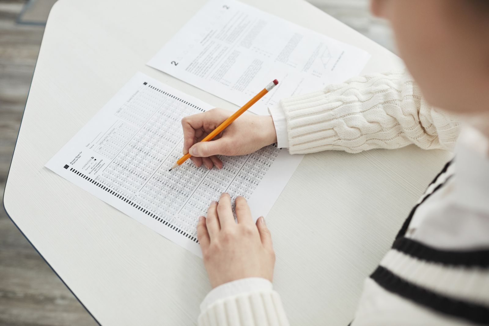 Close-up of a student filling out a multiple-choice exam in a quiet classroom setting; New Jersey ABC test