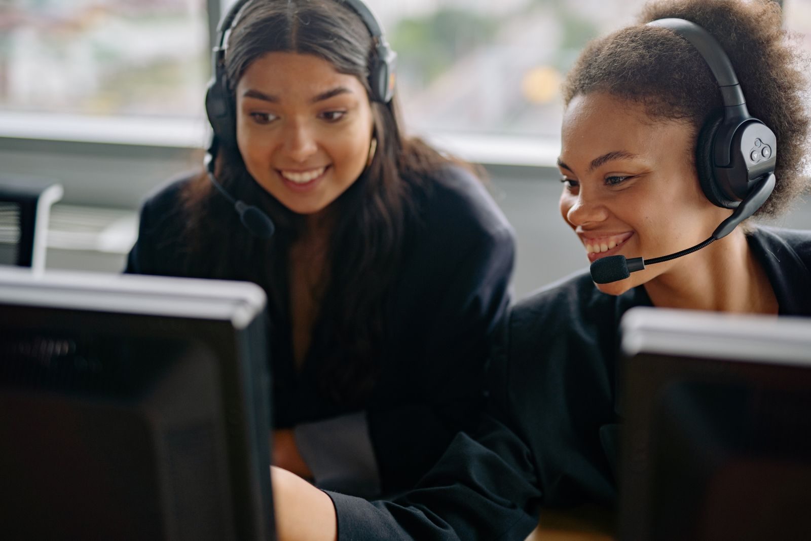 Two cheerful call center agents at work, engaging with customers and providing support; AI agent liability